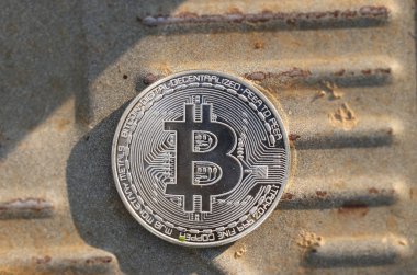 Demir tahtanın ortasındaki bir gümüş bitcoin. Dünyanın yeni para birimi