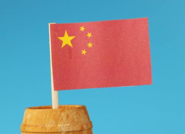 Kağıt ahşap varil içinde ahşap çubuk üzerinde Çin'in ulusal bayrak bir detay. Mavi arka plan