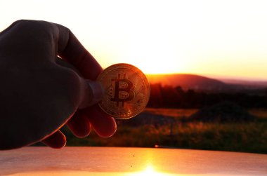 Dağları ile güzel bir gün batımı ve orada da el altın bitcoin ve araç çatı. Güzel arka plan