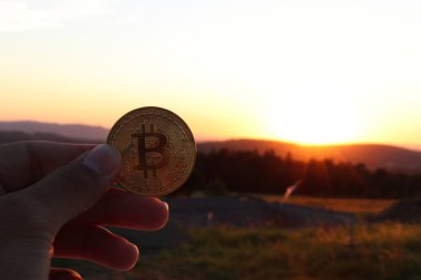 Altın bitcoin ve arka plan günbatımı. Yatırım, sanal para. Şifreleme için yatırım