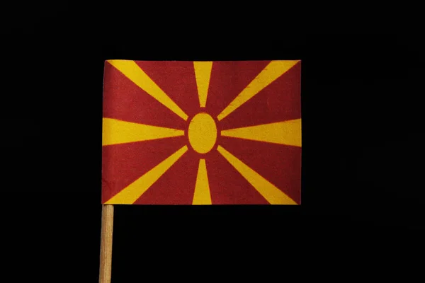 ユニークな非常にオリジナルの国立は 黒い背景につまようじにマケドニア共和国のフラグです 拡大光が中心からエッジまでの赤い野原で様式化された黄色い太陽 — ストック写真