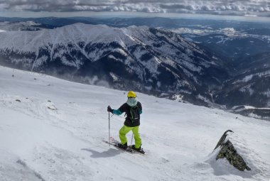 Freeride için en iyi parça bulma bir adam kayakçı. Bir kayakçı vadiye bakıyor. Sarı bir kask. Doğru zamanı bekliyor. İyi seçim. Chopok, düşük Tatras, Slovakya