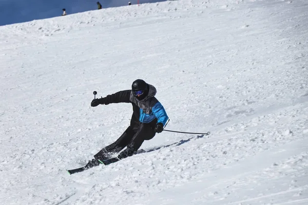 Un esquiador masculino esquiando cuesta abajo en Chopok, Eslovaquia. Posición de tallado. Gire a la izquierda. Freeride. Posición difícil. Chaqueta negra y gris. Carrera oficial. Prepárate para el campeonato —  Fotos de Stock