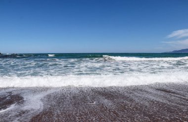 Köpük ve üfürüm ile kıyıda güzel dalgalar. KuzeyKıbrıs'ta Polis adlı küçük bir şehir deniz kıyısında Akdeniz denizi. Mavi gökyüzü ve berrak deniz