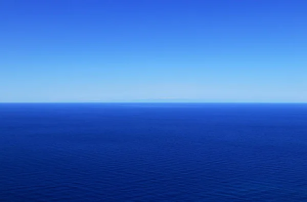 Cielo sin nubes con matices cambiantes de azul y oscuro mar mediterráneo. En el fondo están las montañas de Turquía. Soleado cielo azul veraniego y mar. Océano abierto en zona libre — Foto de Stock