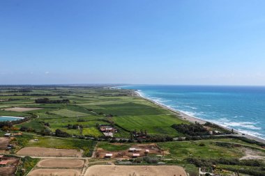 Kouklia tepesinden Dünya'nın yuvarlaklık kanıtı görünümü. Antik Kourion, Episkopi, Kıbrıs güzel bir görünüm. Turistler yeşil ülke ve dalgalar dolu mavi deniz arasındaki kontrast görebilirsiniz