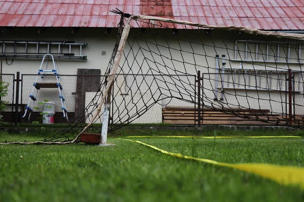 Handmade created softenis net. It was built on the garden and serves for game as typical softenis net. It was used volleybal net and iron stick for attachment. Yellow tape is playground