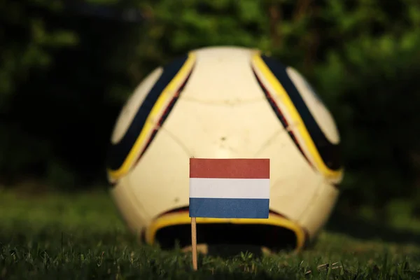 Estado símbolo de los Países Bajos apuñalado en el patio de recreo y en la pelota de fútbol de fondo antes de mejores miradas. Campeonato del Mundo 2022. Euro 2020. Partido internacional —  Fotos de Stock