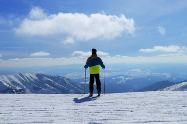Slovakya 'daki Demanovska Vadisi' nin Panorama 'sı. Kayakçı gezintiye hazır. Çocuk bu güzel manzaraya doyamıyor. Kış sporu kavramı. Becerikli erkek kayakçının arka planı