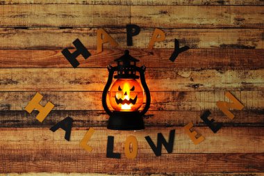 Uğursuz atmosfer için korkunç bir fener valesi. Mutlu Cadılar Bayramı kelimesi kağıttan siyah ve turuncu harflerden oluşur. Şaka ve şeker. Alfabedeki harfler 