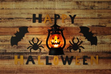 Cadılar Bayramı feneri Jack O Lantern ile gülümsüyor. Ekim 'de çılgın bir tatil. Çocuklar için çok stresli ve uğursuz günler. Sonbahar temalı natürmort. Sarı ve siyah harfler.