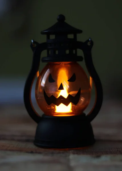 Een close-up lantaarn jack. Lamp in vorm angstaanjagend lachend aan de zijkant van het glas. Typische versiering voor Halloween avond feest. Oranje licht is de basis steen van deze nationale feestdag — Stockfoto