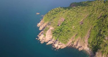 Günbatımında, Endonezya, Bali 'de, turkuaz dalgalı bir deniz tarafından yıkanan güzel adanın göz kamaştırıcı manzarası. Endonezya 'da yaz günü mavi gökyüzünün altındaki dağlara karşı plantasyonlar