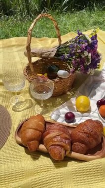 summer picnic outdoors basket with flowers, fruits, croissants, watermelon