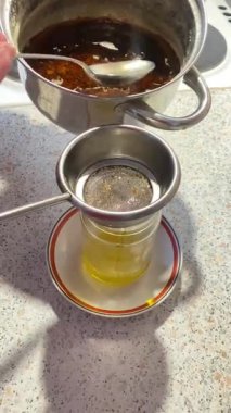 Straining melted ghee through a sieve