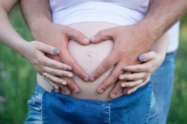 Erkekler ellerini dikkatle hamile eşi, babalık kavramı göbek kucaklamak