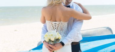 Gelin ve damat güzel bir plajda gün batımında romantik evli çift