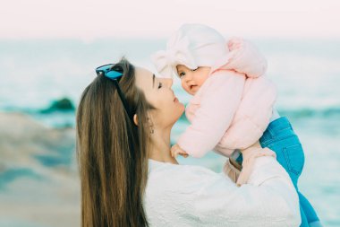 Anne ile kızı kumsalda oynarken. Anne kızını sarılma.