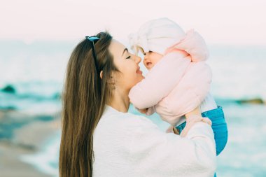 Anne ile kızı kumsalda oynarken. Anne kızını sarılma.