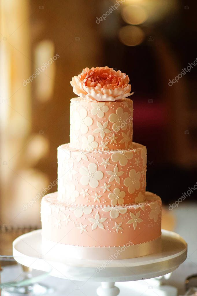 wedding cake decorated with white flowers on the restaurant background