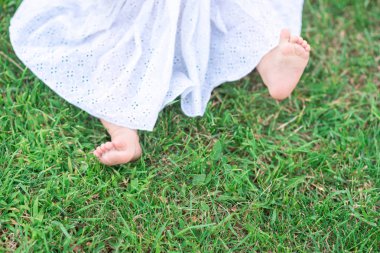 bir çocuğun yeşil çim bahçe içinde yalınayak bacaklar. mutlu annelik kavramı. yaz