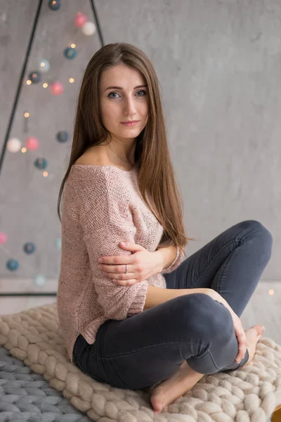 Młoda Piękna Dziewczyna Długimi Włosami Różowym Swetrze Siedzi Tle Urządzone — Zdjęcie stockowe