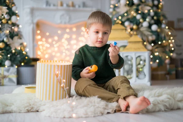 Kisfiú Teszi Vicces Arcok Kandalló Évet Dekorációt Füzér Karácsonyfákkal Ajándékokkal — Stock Fotó