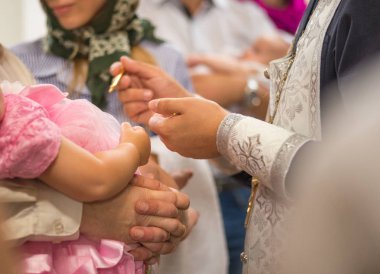 Rahip Vaftiz ayini gerçekleştirir. yağlı boya bir kız bebek eller üzerinde haçlar