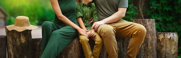 Familia feliz de los turistas padres abrazando a su hijo y sentado o — Foto de Stock