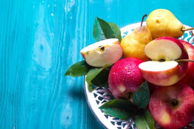 Olgun kırmızı elma ve sarı armut tablonun yan metin için yer ile resmi bir tabağa yalan