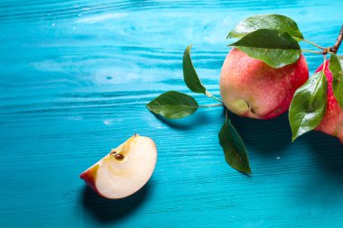 kırmızı elma bir parça tüm elma yanındaki bir masada yatıyor