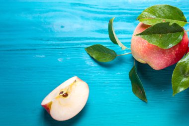 kırmızı elma bir parça tüm elma yanındaki bir masada yatıyor