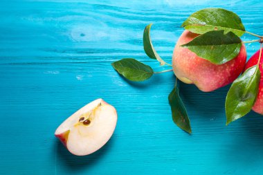 kırmızı elma bir parça tüm elma yanındaki bir masada yatıyor
