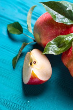 kırmızı elma bir parça tüm elma yanındaki bir masada yatıyor