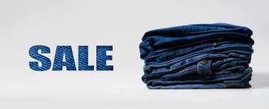 Mavi Satılık işareti ile yığın, mavi kot pantolon beyaz arka plan