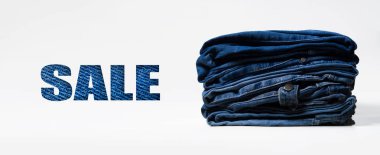 Mavi Satılık işareti ile yığın, mavi kot pantolon beyaz arka plan