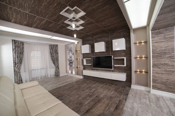 modern design of the rest room with combined wooden parquet lighting fixtures with white sofa and large plasma TV on a dark wooden wall