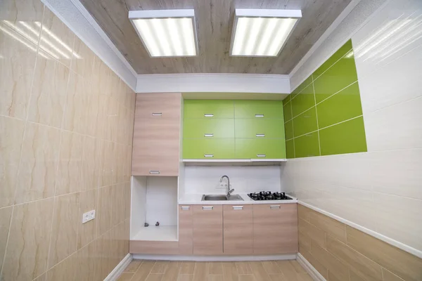 Luxurious laundry in the house with green cupboards, light parquet and a wardrobe with a drawing