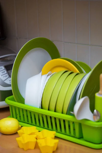 On the drying rack clean dishes, dishes, spoons, forks, silicone molds for cupcakes , limon on yellow