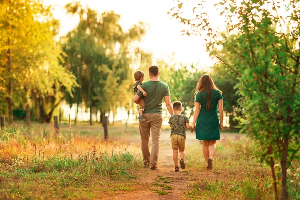 kavram aile park tatil. Bir ailenin dört anne, oğlu, Childs'ın el walkingat günbatımı tutan anne tutan baba