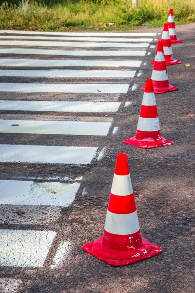 Road cones signal with two reflective stripes on the road with a pedestrian crossing. repair work