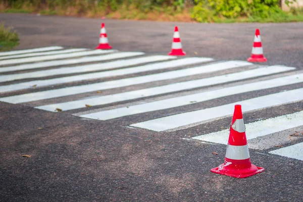 Road cones signal with two reflective stripes on the road with a pedestrian crossing. repair work