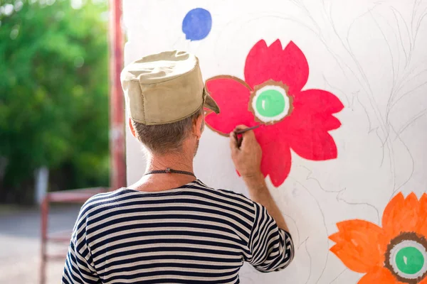 Man Paints Paints Paint White Wall Floral Ornaments Summer — Stock Photo, Image