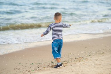 Genç bir çocuk iken tatilde plajda eğleniyor. deniz