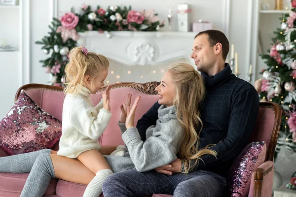 Boldog család csíkos Pullover - anya, apa és lánya - játék, és nevetve egy téglafal háttér-izzó fények, karácsony fénykép — Stock Fotó