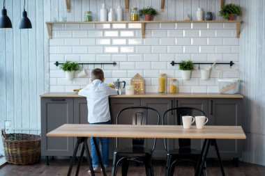 Yakışıklı çocuk mutfakta masada yemek