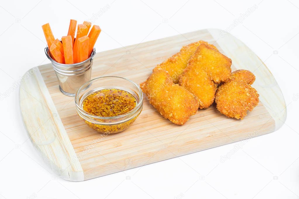 chicken nuggets with sauces on wooden board