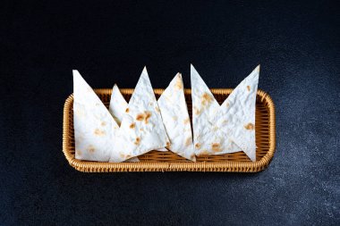 Ev yapımı mayalanmış Hint ekmeği sepette, tepede koyu ahşap üzerinde fotoğraflanmış. en üstteki görünüm