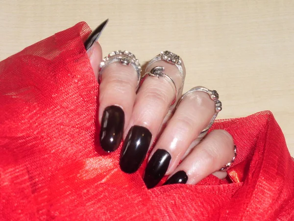 Manicure nera su una donna mani con shiffon rosso. Nail Art Design — Foto Stock