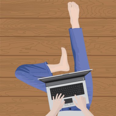 Bir dizüstü bilgisayar ile bir ahşap zemin üzerinde çalışan bir blogger 